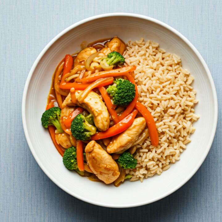 Chicken stir fry with peppers on a white plate